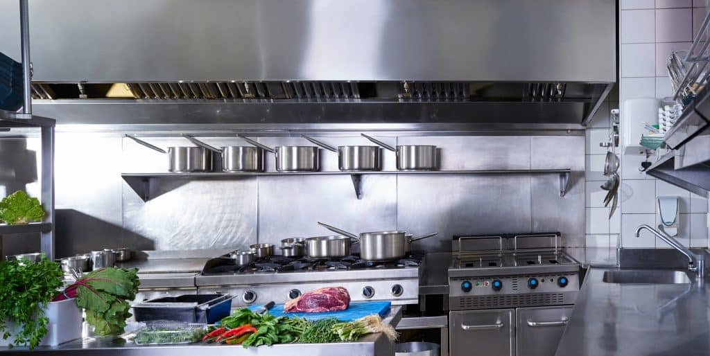 Professional restaurant kitchen in stainless steel with vegetables and meat